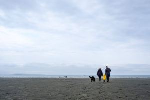 family of four walks on the cloudy beach in homer alaska