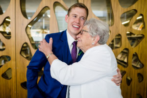 groom gets a hug from his grandma after his wedding