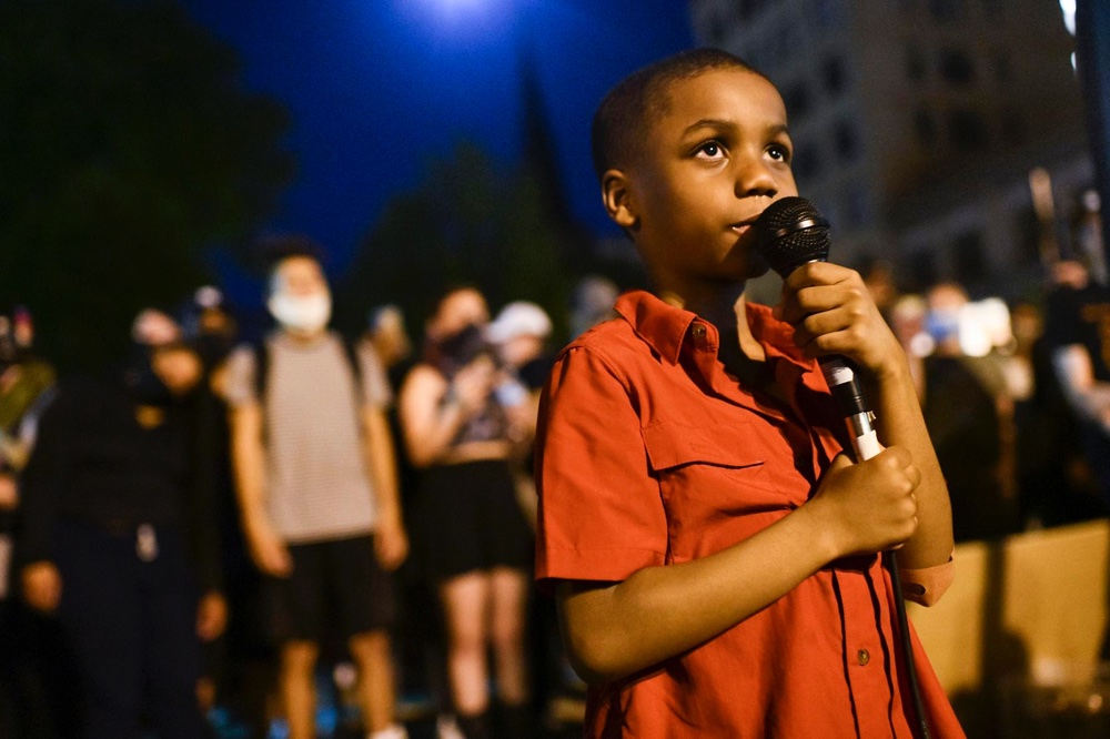 A young child holds a mic and speaks to a crowd gathered in Madison Wisconsin to celebrate Breonna Taylor's birthday.